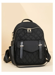 Détail du sac à dos noir matelassé avec fermetures éclair dorées et boucles en cuir