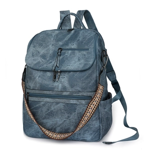 Vintage navy blue multi-pocket backpack with patterned woven strap in a 45-degree view