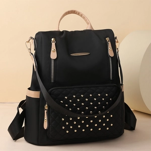 Details des schwarzen Nylon-Rucksacks mit Goldnieten und metallischen Reißverschlüssen