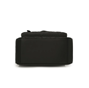 Vue détaillée du fond renforcé d'un grand sac à dos en nylon noir avec doubles coutures