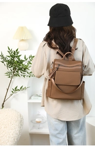 Detail of vintage brown leather backpack featuring geometric texture and tassel charm