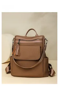 Detail of warm brown woven leather backpack with fringe tassel and side pocket view