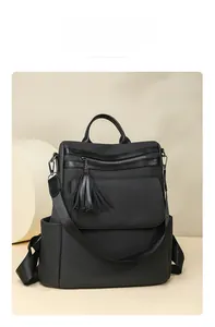 Detail of a black tassel backpack showing the magnetic front pocket and premium texture