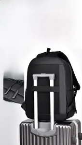 Detail of backpack with luggage strap fixed on suitcase handle for business travel