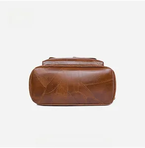 Detail view of the brown PU leather backpack bottom showing intricate leaf-pattern stitching