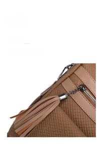 Close-up of the vintage tassel zipper detail and woven texture on brown leather backpack