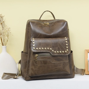 Close-up of vintage brown PU leather backpack with gold rivets and dual zipper details