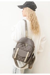 Détail du sac à dos en nylon gris matelassé avec poche à rabat et rangement latéral