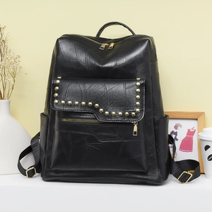 Detail of black PU leather backpack showing gold studs and multiple functional pockets