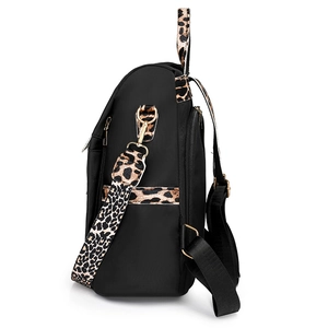 Minimalist black nylon backpack featuring trendy leopard print straps and gold hardware