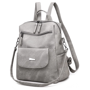 Detailed view of light gray multi-pocket backpack with metal buckles and durable fabric texture