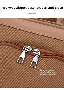 Detail of premium brown textured fabric with ergonomic silver dual metal zippers for smooth closing