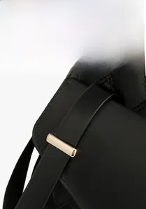 Détail de la boucle de ceinture et texture matelassée sur un grand sac à dos noir