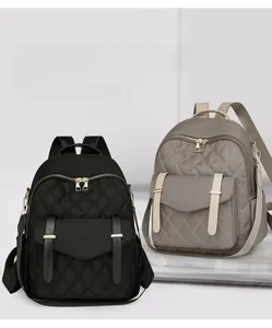 Détails du sac à dos en nylon matelassé noir et gris avec des fermetures éclair dorées
