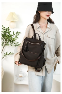 Detail of dark brown vintage backpack with tassel zipper and water-resistant nylon texture