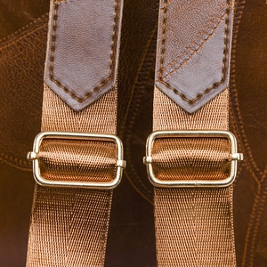 Detail of dark brown leather strap with gold metal buckle and reinforced stitching