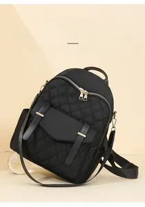 Détail du sac à dos en nylon noir matelassé avec fermetures éclair dorées chic