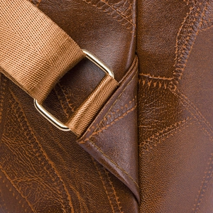 Macro shot of brown PU leather texture with golden buckle and woven shoulder strap