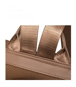 Detailed view of reinforced stitching and woven straps on a vintage leather backpack