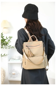 Detail of khaki woven backpack with fringe tassel zipper and adjustable straps