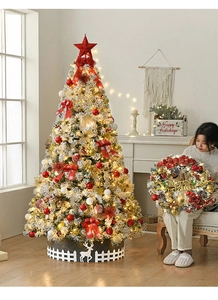 Close-up of snow-dusted Christmas tree with red bows, gold baubles, and warm LED lights