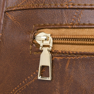 Detail of golden metal zipper and vintage texture on brown PU leather backpack