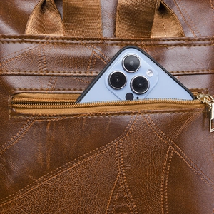 Detailed back zipper pocket on brown PU leather backpack showing storage for smartphone
