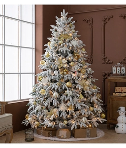 Detail of luxury flocked Christmas tree with gold ornaments and warm LED string lights
