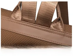 Close-up of durable fabric texture and neat stitching on dark brown backpack strap