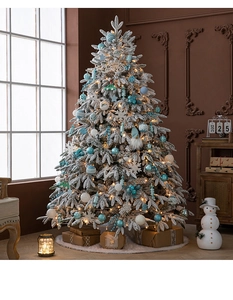 Detail of luxury 1.8m flocked Christmas tree with blue ornaments and warm LED lights