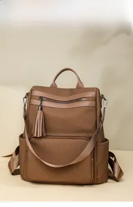 Detail of brown multi-zone backpack showing fringe zipper and fabric texture