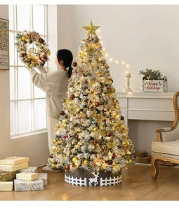 Detailed view of flocked Christmas tree with golden ornaments, lights, and fence base