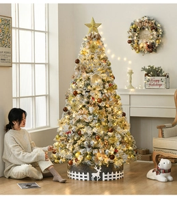Detail of 2.1m flocked snow Christmas tree with gold ornaments and reindeer tree skirt