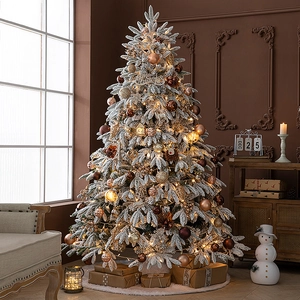 Deluxe snow-flocked Christmas tree with warm LED lights and elegant golden ornaments