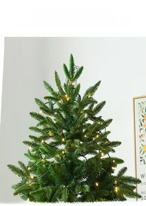 Détail d'un sapin de Noël artificiel vert avec des guirlandes lumineuses LED jaune chaud