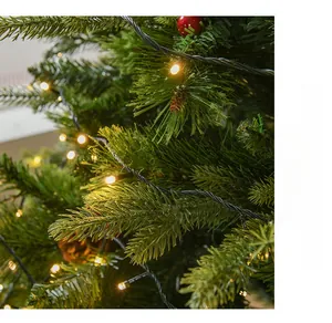 Dettaglio rami di pino sintetico folto con luci LED bianco caldo e pigne decorative