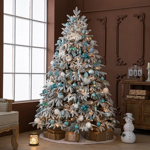 Flocked artificial Christmas tree with blue-white ornaments and warm LED lights