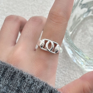 Minimalist silver interlocking horsebit ring shown on finger with high polish finish