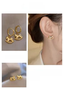 Vue détaillée de boucles d'oreilles carrousel dorées avec texture effet glace pilée