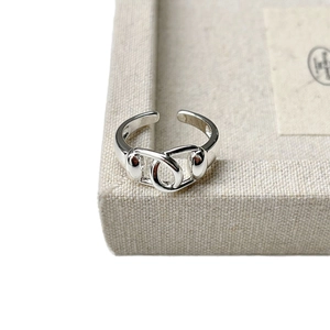 Minimalist silver interlocking oval link ring with polished finish on a linen display