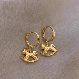 Boucles d'oreilles cheval à bascule dorées avec texture sur fond en satin élégant