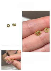 Close-up of gold asymmetrical horse and coin stud earrings with hollow design details