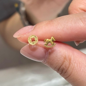 Asymmetric gold horse and coin stud earrings with textured frosted finish for women