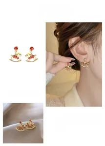Macro detail of golden rocking horse earring with red enamel and micro-paved rhinestones