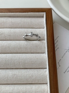 Macro detail of silver bamboo joint ring with micro-set zircon in beige velvet box