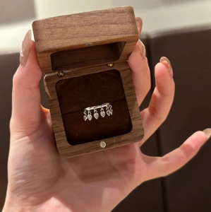 Silver drop tassel ring with pear-cut cubic zirconia displayed in a premium wood box