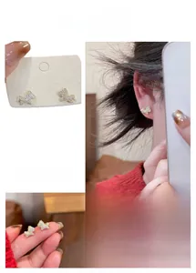 Close-up of golden horse stud earrings with white zircons and model wearing visual