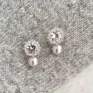 French snowflake pearl stud earrings with sparkling cubic zirconia on a knit fabric