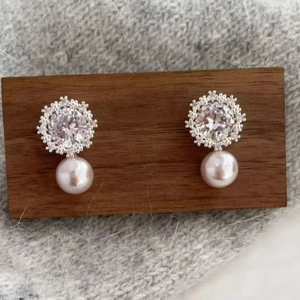 French style snowflake pearl earrings with sparkling cubic zirconia on a wooden display