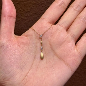 Collana dorata con ciondolo a goccia a quattro livelli con cristalli e finitura opaca raffinata